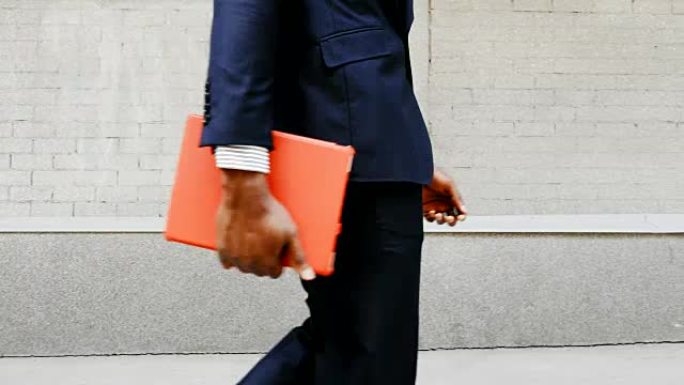 非裔美国商人带着平板电脑在户外散步