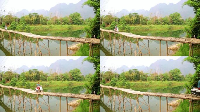 老挝石灰石景观摩托车穿越竹桥的快乐游客