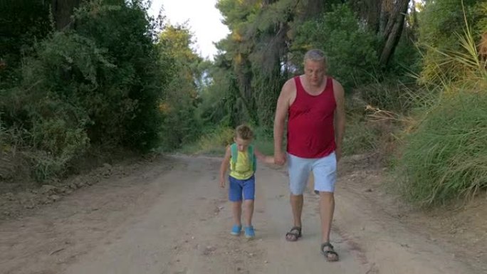 男人和男孩沿着乡间小路徒步旅行