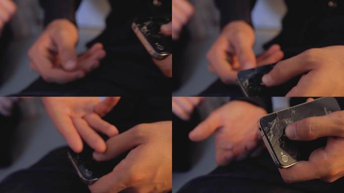 男子手里拿着屏幕破裂的智能手机