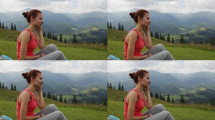 年轻女子在山顶用手机交流，背景是美丽的峡谷