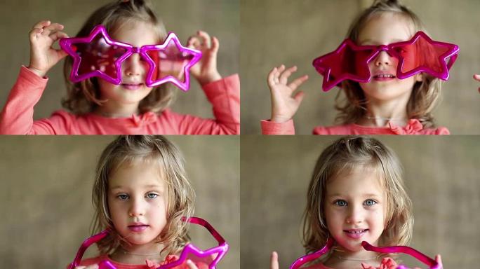 戴着星星形状的大眼镜的漂亮小女孩看着相机