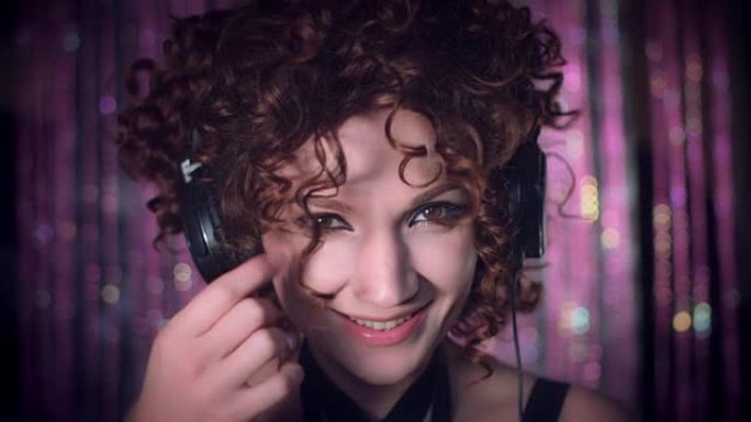 4k迪斯科卷曲性感女人用耳机摆出俏皮的姿势