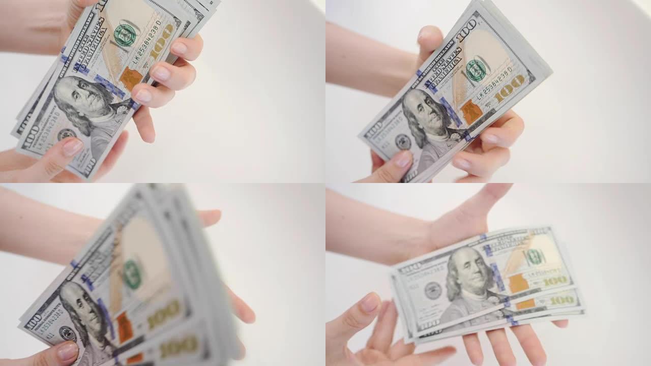 一个女人手里拿着几百美元，把钱拍在手掌里。慢动作