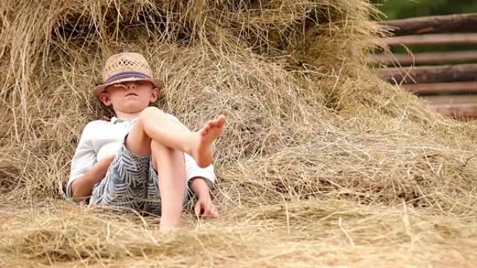 小男孩在一堆干草旁放松
