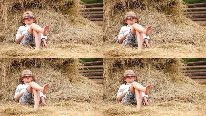 小男孩在一堆干草旁放松