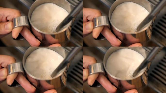 咖啡师用机器蒸热卡布奇诺咖啡的牛奶