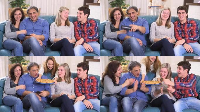 幸福的家庭在家里看电视吃披萨