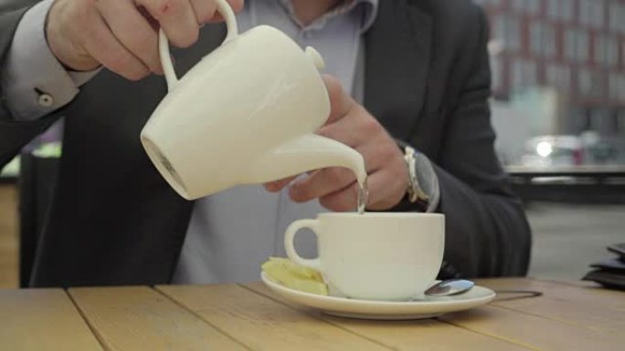 靠近商人的手，将茶倒入杯中，steadicam。