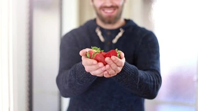 男人手里拿着新鲜草莓的观点