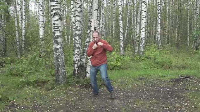 穿着便服的男人在林间空地上打架武术，慢动作
