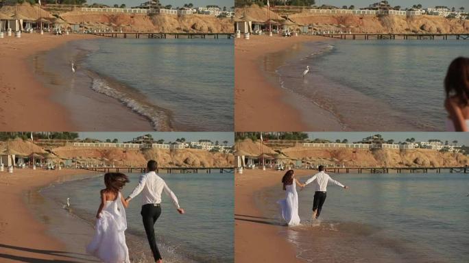 幸福的新婚夫妇在冲浪上奔跑。埃及的蜜月