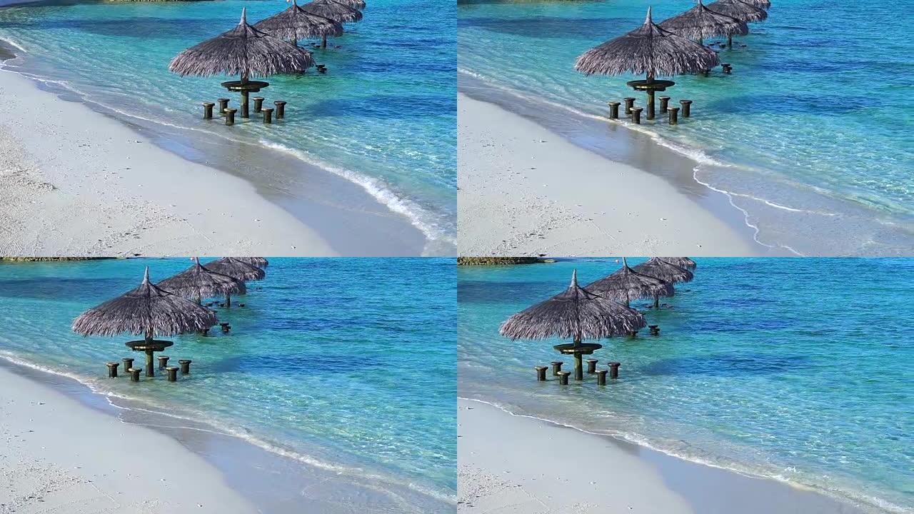 马尔代夫海滩的海洋酒吧。绿松石蓝色大海中的热带小屋座位以慢动作拍摄