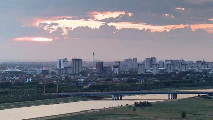 日落在桥上延时，背景是交通和云层。中亚、哈萨克斯坦、阿斯塔纳