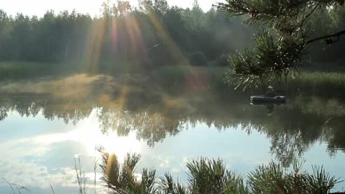 渔夫乘充气船漂浮在河上。太阳的光线在框架中播放。野外活动