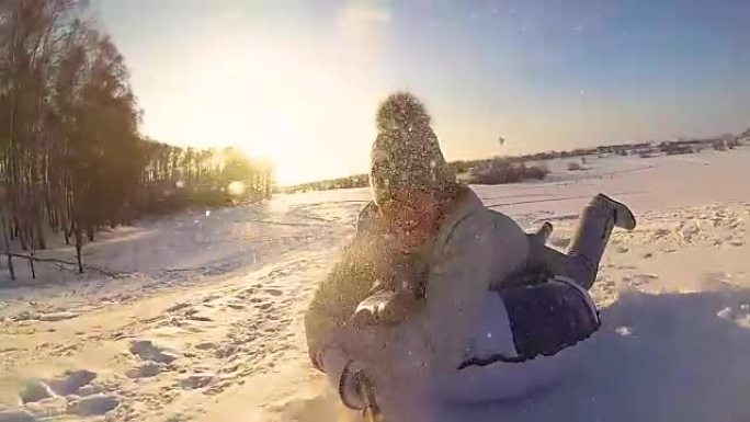 快乐的女孩在下雪的道路上骑行和微笑的雪管。慢动作。雪冬景观。户外运动