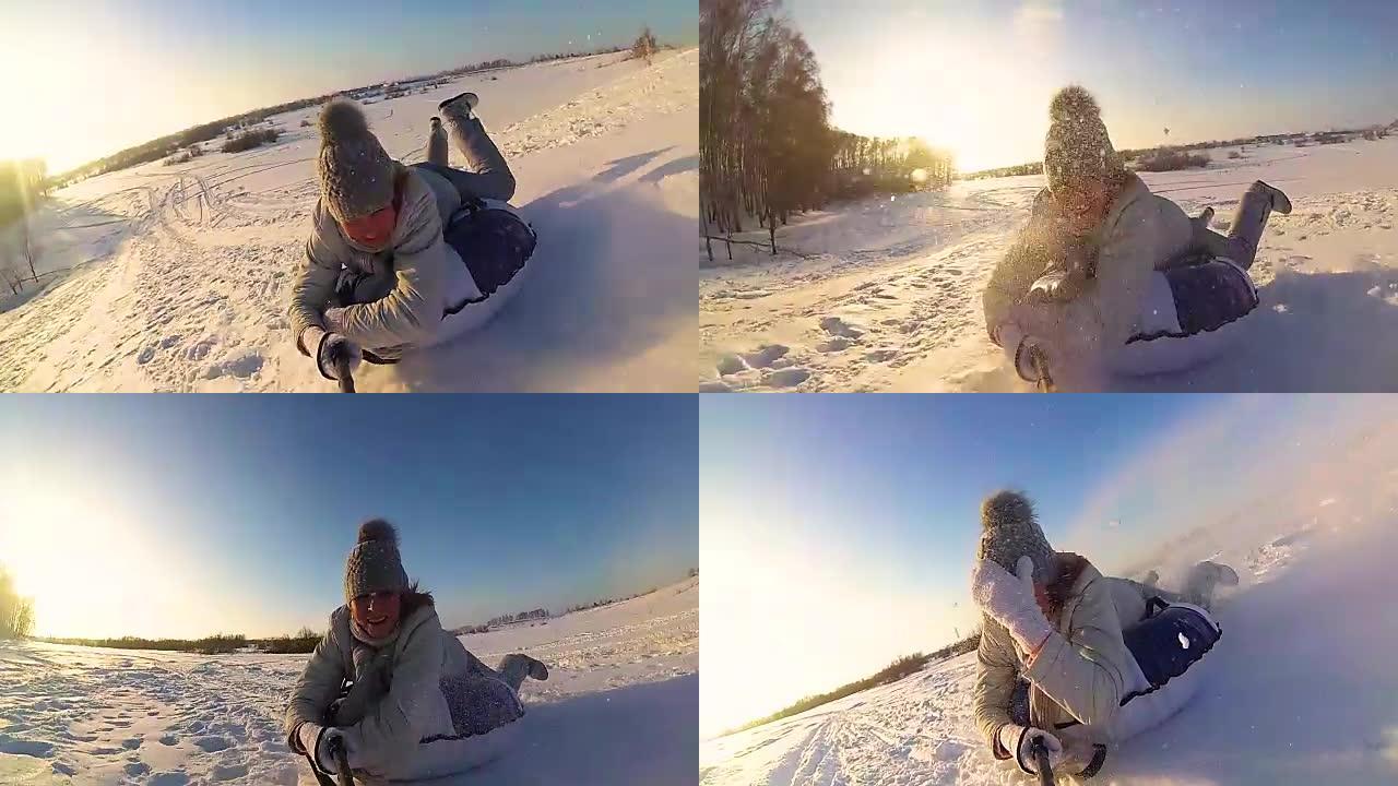 快乐的女孩在下雪的道路上骑行和微笑的雪管。慢动作。雪冬景观。户外运动