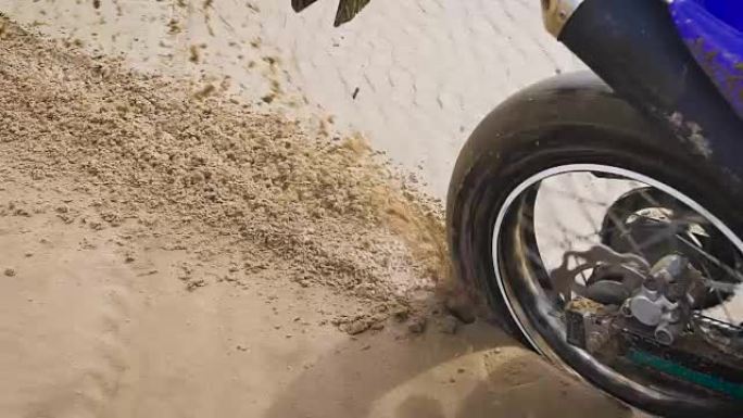 摩托车手在后轮撒沙子