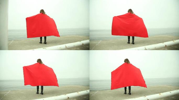 海边红色毯子孤独女孩的背影