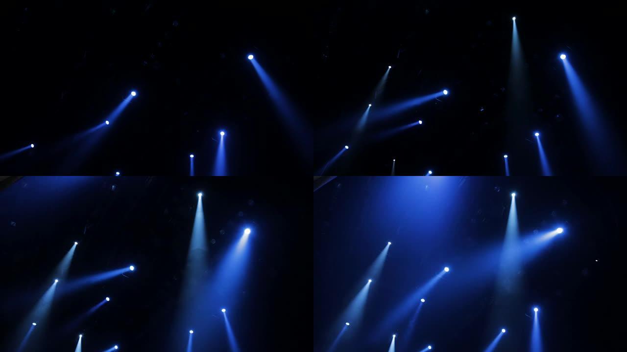 演出期间，聚光灯下的蓝光穿过剧院的烟雾。照明设备