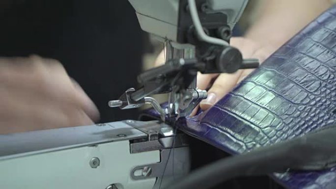 工厂生产真皮皮包的概念。缝纫机上的缝合袋特写