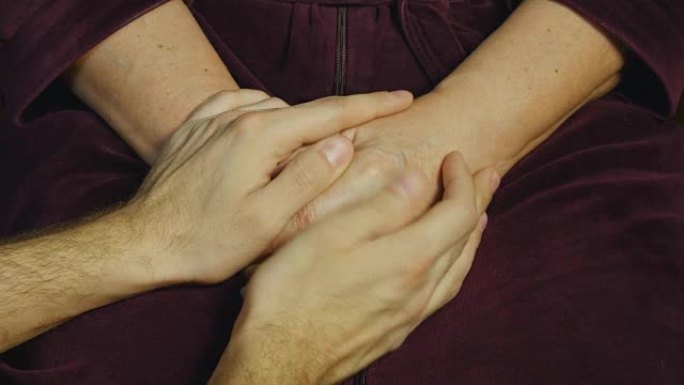 男性的手安慰一双老人的手。