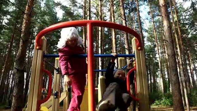 男孩和女孩在公园的儿童滑梯上玩得开心。孩子们笑着放纵。周日假期，孩子们在公园里。