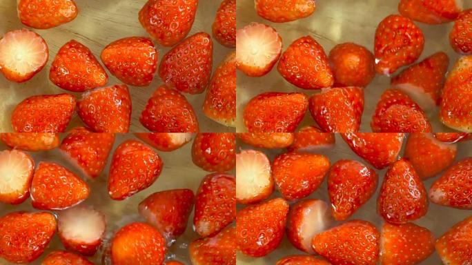 新鲜的红色草莓倒入一碗水中，缓慢