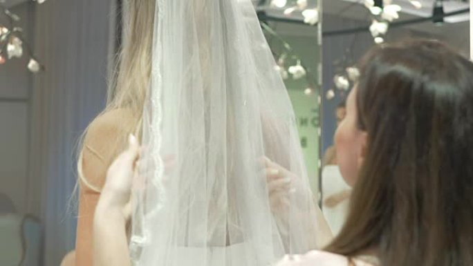 婚礼精品店里穿新娘面纱的女孩