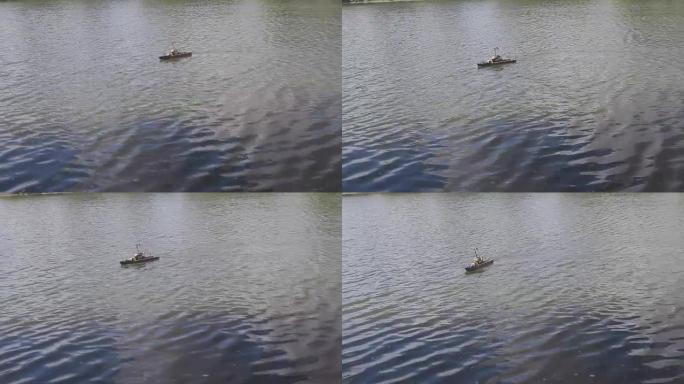 人们在池塘里驾驶遥控木制游艇。
