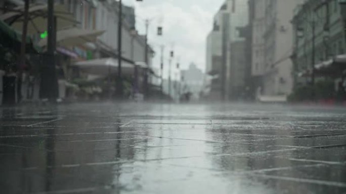 城市街道大雨日的背景。实时。雨中带伞的人上下班。模糊的波克。自然背景