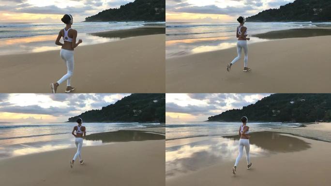 穿着运动服的年轻女孩在海滩上跑步