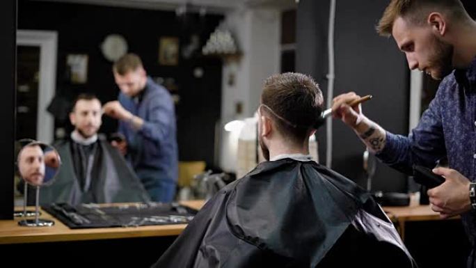 理发师和男性顾客。美发师用刷子清洁顾客剪掉的头发。理发店