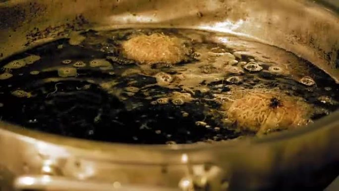 用沸腾的食用油在热锅中圆形面团