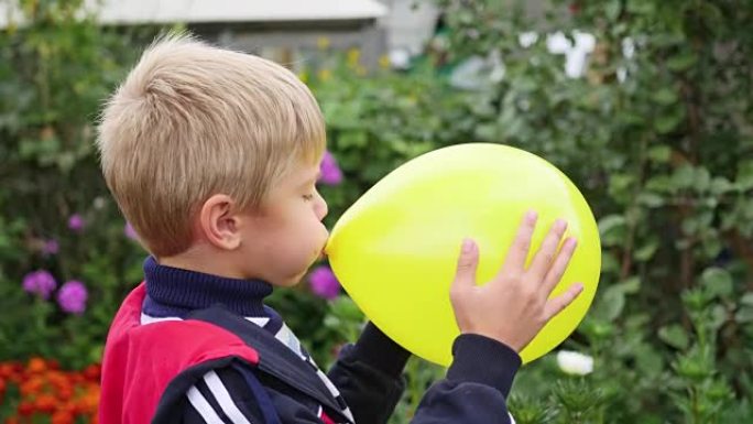 花园里的孩子给黄色气球充气