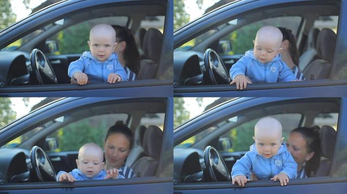 母亲带着婴儿坐在汽车上的驾驶座上。孩子玩微笑