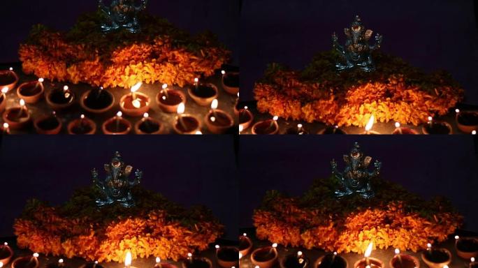 甘尼萨勋爵 (lord ganesha) 与粘土油灯和鲜花，ganesh chaturhti节并为印