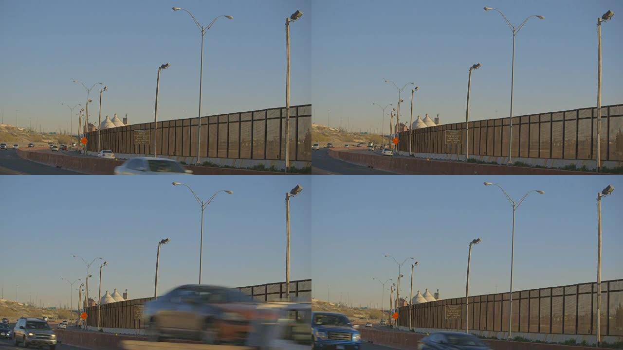 边境围栏旁高速公路上的车辆