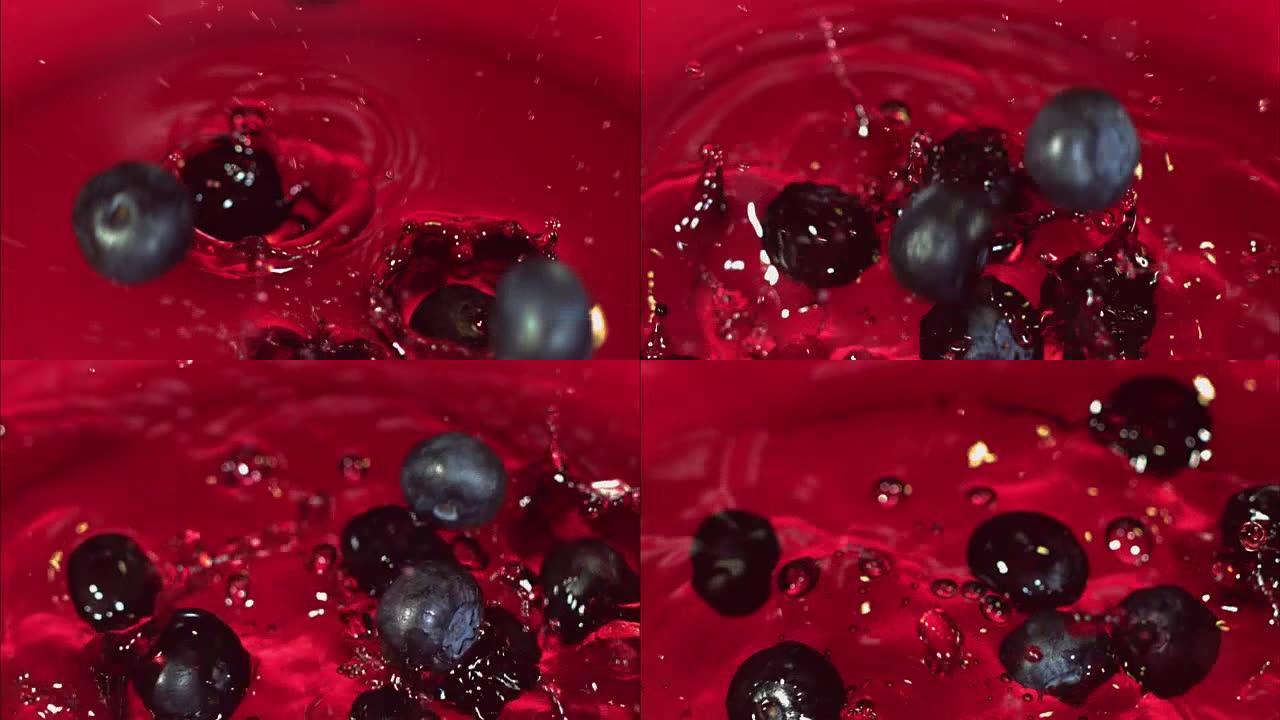 蓝莓掉入带有果汁的玻璃碗中