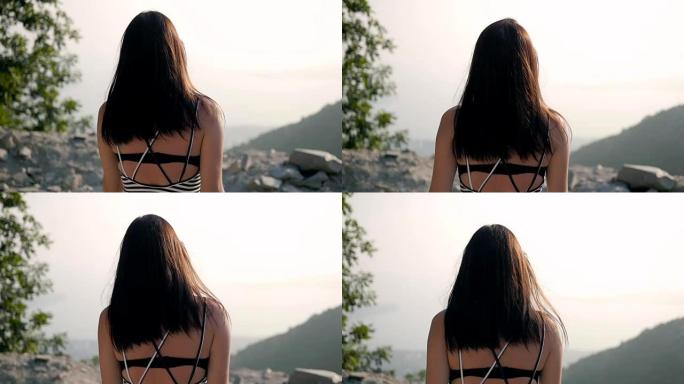 年轻黑发女人去山边的背景图