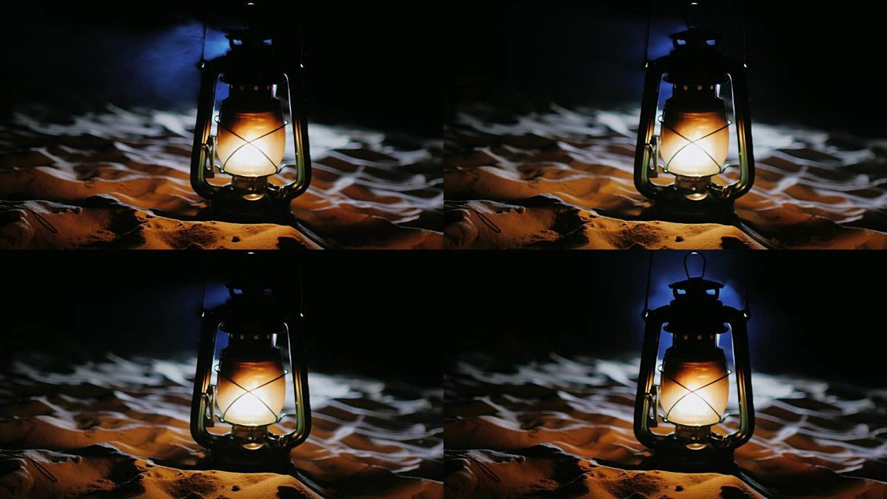 老式油灯站在沙滩上，在黑暗中发光