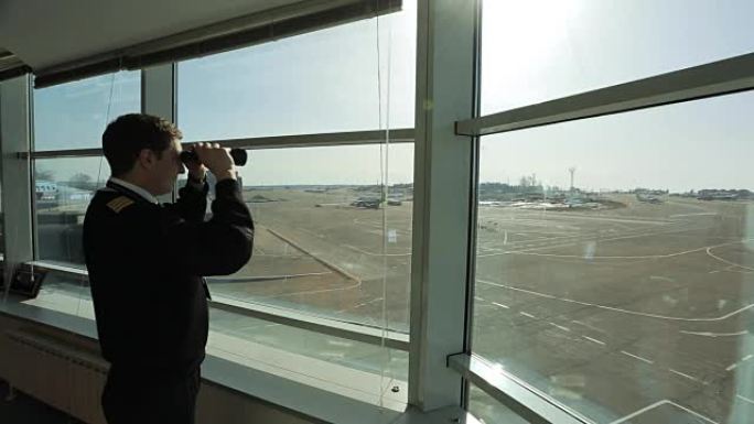 空中交通管制员正在用双筒望远镜观察机场的距离