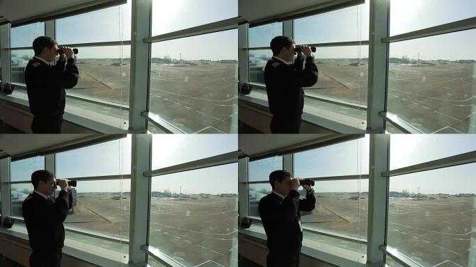 空中交通管制员正在用双筒望远镜观察机场的距离