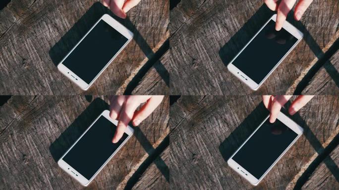 手指手势女孩在木制背景上管理智能手机