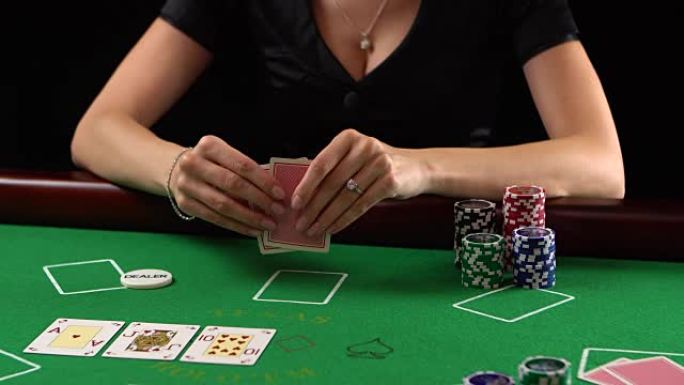 扑克玩家看着她的牌和折叠。赌博、风险、运气、赢、乐趣和娱乐的概念。普洛雷斯·富勒德