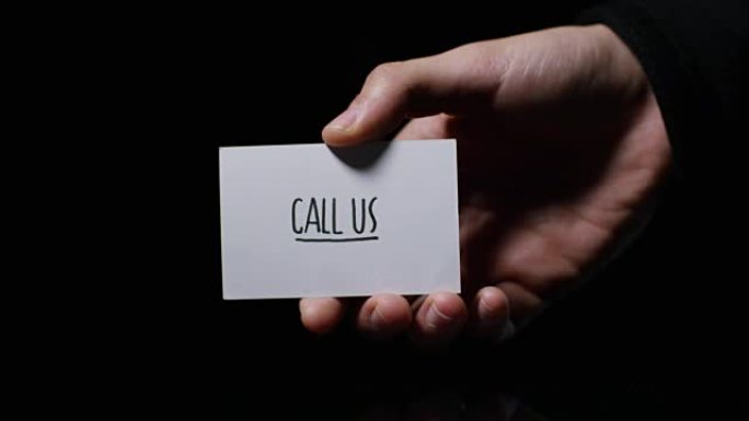 一只手展示一张卡片，上面写着: “打电话给我们”。商业概念，感谢，记录网站，客户服务，沟通和商业联系