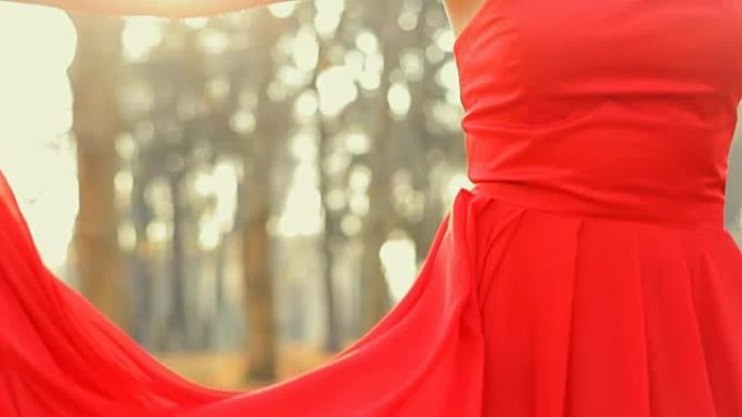 漂亮的年轻模特穿着红色长晚礼服，专业地在相机上摆姿势。