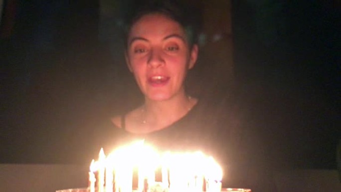 女人吹生日蛋糕。年轻女子庆祝自己的30岁生日