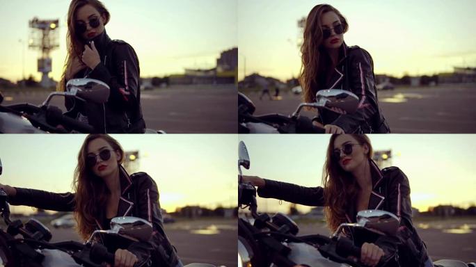 一个穿着皮夹克和短裤的女骑自行车的人坐在自行车上，拿着车把的肖像。直升机上戴着太阳镜的年轻性感卷发女