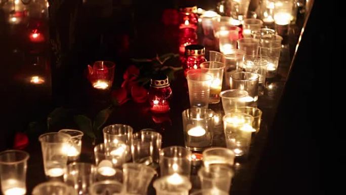纪念碑上的鲜花和蜡烛，以纪念恐怖袭击受害者的受害者。恐怖袭击的后果，军事行动。人们哀悼和哀悼死者